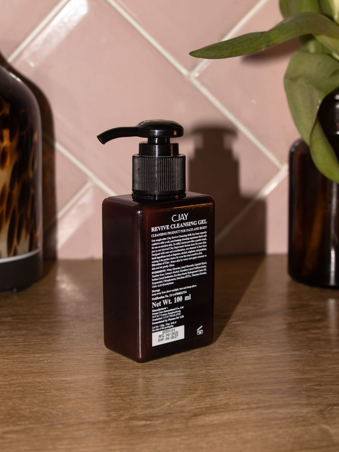 CJAY Revive Cleansing Gel bottle on a checkered floor background